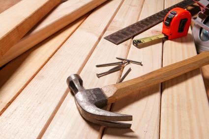 hammer and nails laying on a stack of lumber